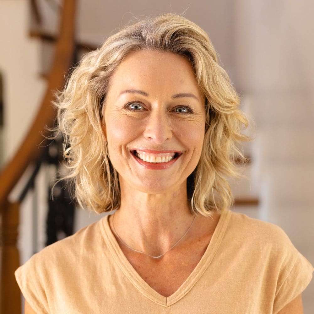 Portrait of caucasian senior woman smiling while standing in the living room at home. people and emotions concept, unaltered.